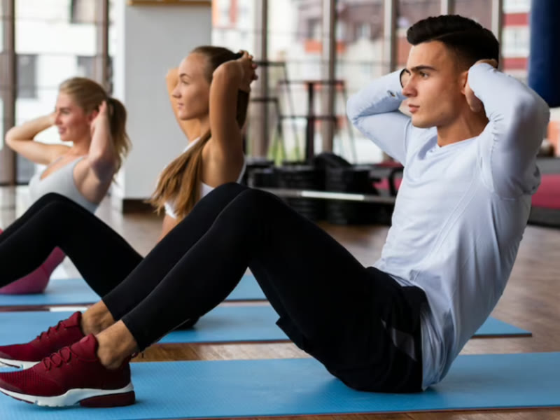 A group practising together on exercise mats in a bright studio